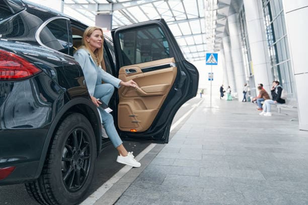 une personne qui descend d'une voiture privé noir.